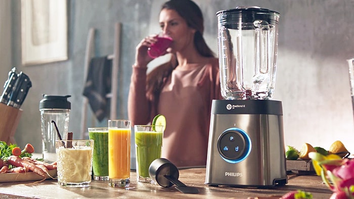 mujer usando una batidora de Philips