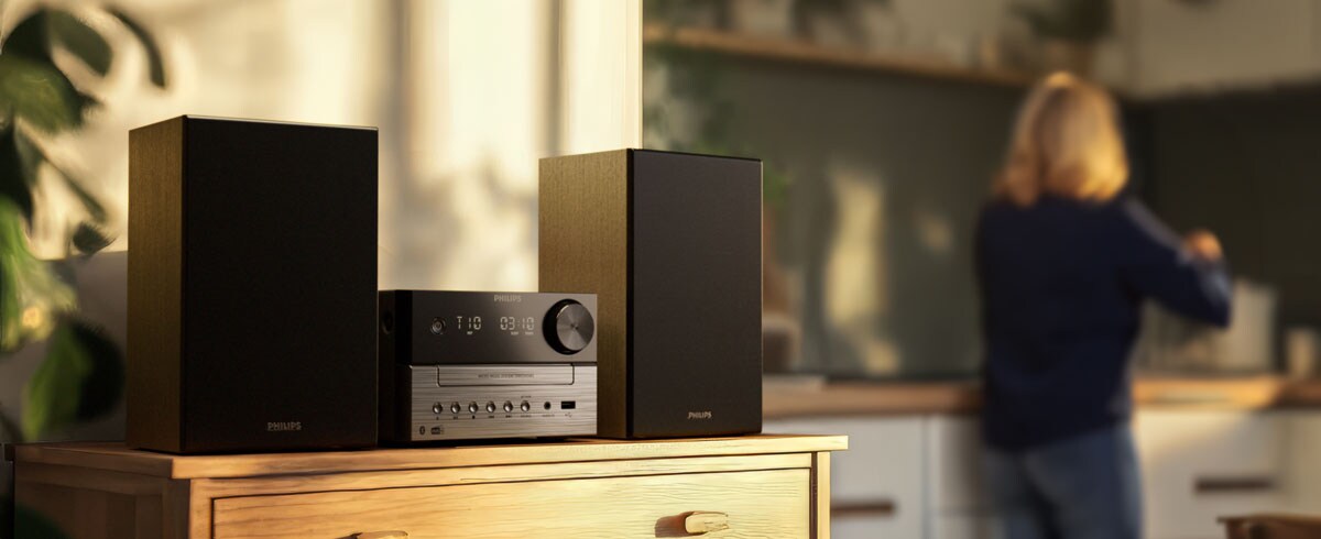 Mujeres escuchando música en la cocina con un sistema de música de Philips
